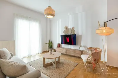 a living room with a couch and a tv at Free-Spirit Large Boho Apartment with Free-Parking in Athens