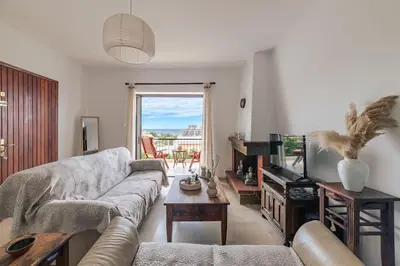 a living room with a couch and a television at Seaside escape apartment in Saronida
