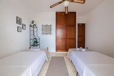 a room with two beds and a wooden door at Seaside escape apartment in Saronida