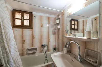 a bathroom with a tub and a sink and a mirror at Seaside escape apartment in Saronida