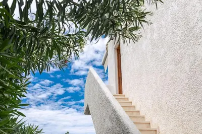 a staircase leading up to a white building with a blue sky at Seaside escape apartment in Saronida