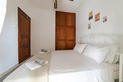 a bedroom with a white bed with two towels on it at Seaside escape apartment in Saronida