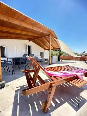 a hammock on a patio with a table and chairs at Boomers Attic Athens in Koropíon