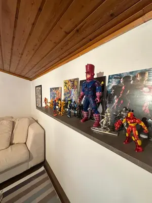 a shelf with toy figurines on a wall at Boomers Attic Athens in Koropíon