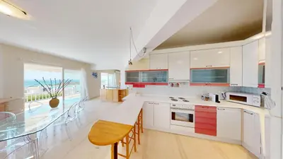 a kitchen with white cabinets and a large window at Raise Riviera Panoramic Sea View apartment in Athens