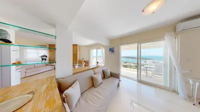 a living room with a couch and a view of the ocean at Raise Riviera Panoramic Sea View apartment in Athens
