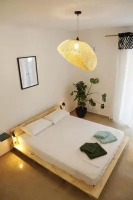 a bed in a room with a potted plant at Zorba Meets Buddha in Athens