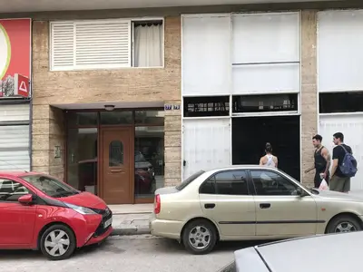 two cars parked in front of a building at Zorba Meets Buddha in Athens