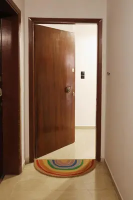 a wooden door with a colorful rug on the floor at Zorba Meets Buddha in Athens