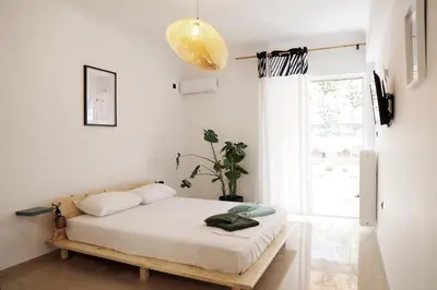 a bedroom with a bed and a large window at Zorba Meets Buddha in Athens