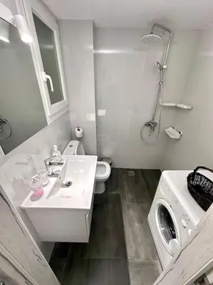 a white bathroom with a sink and a washing machine at Jorges house in athens in Athens
