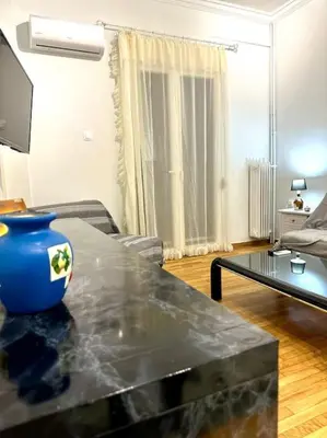 a living room with a blue vase on a table at Jorges house in athens in Athens