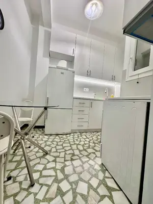 a kitchen with white cabinets and a glass table at Jorges house in athens in Athens