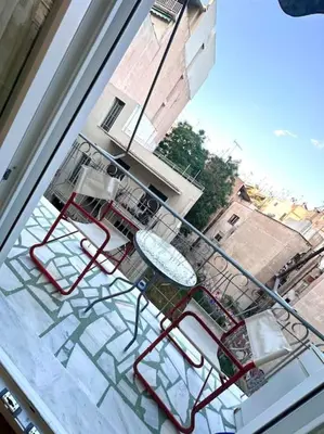 a view of a table and chairs on a balcony at Jorges house in athens in Athens