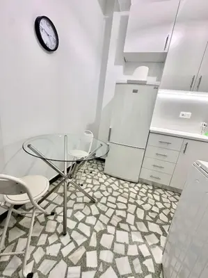 a kitchen with a table and two chairs and a clock at Jorges house in athens in Athens