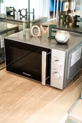a microwave oven sitting on top of a wooden floor at ΜΚ Αpartment 2ΥΔ - Nikea Metro in Piraeus