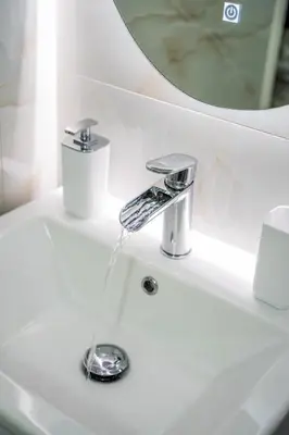 a bathroom sink with water running from a faucet at ΜΚ Αpartment 2ΥΔ - Nikea Metro in Piraeus