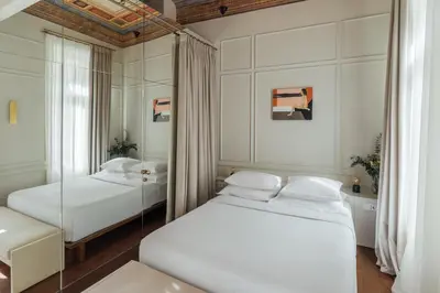 two beds in a room with a mirror at Nosteo in Athens