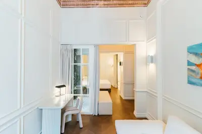 a living room with a desk and a bed in a room at Nosteo in Athens