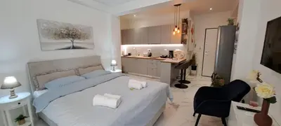 a bedroom with a large bed and a kitchen at Maddie's Apartment in Athens