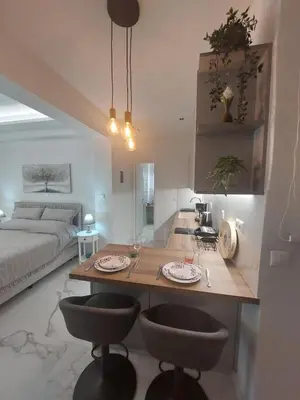 a kitchen and living room with a table and two chairs at Maddie's Apartment in Athens