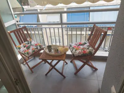 two chairs and a table on a balcony at Maddie's Apartment in Athens