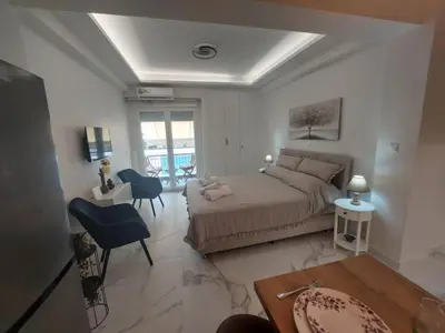a bedroom with a bed and a table and chairs at Maddie's Apartment in Athens
