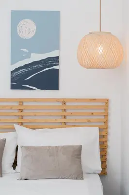 a bedroom with a bed and a pendant light at Sandlight Apartment by A&D Properties in Porto Rafti