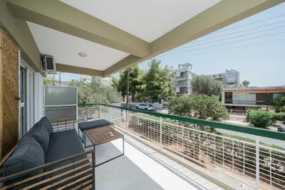 a balcony with a couch and a table at Sandlight Apartment by A&D Properties in Porto Rafti