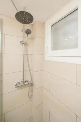 a bathroom with a shower with a window at Sandlight Apartment by A&D Properties in Porto Rafti