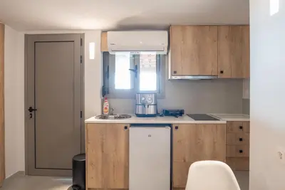 a small kitchen with wooden cabinets and a sink at Tranquility 248 in Athens