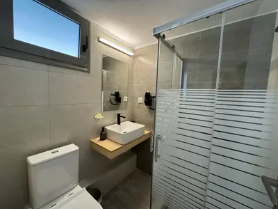 a bathroom with a toilet and a sink and a shower at Tranquility 248 in Athens