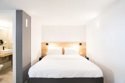 a bedroom with a white bed and a sink at Tranquility 248 in Athens