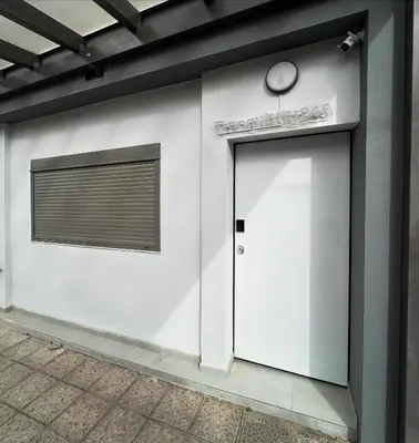 a white building with a door and a window at Tranquility 248 in Athens