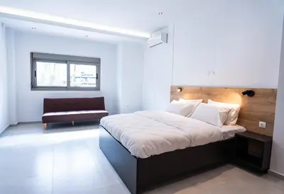a bedroom with a large bed and a couch at Tranquility 248 in Athens