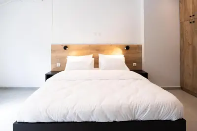 a large white bed with white sheets and pillows at Tranquility 248 in Athens