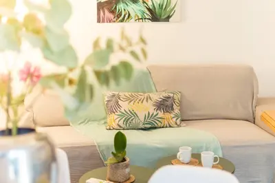 a living room with a couch with a pillow and a table at Urban Nights Athens in Athens