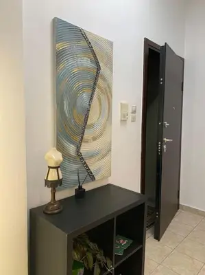 a painting on the wall next to a table with a lamp at Athens Flower Paradise near Acropoli in Athens