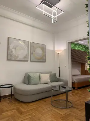a living room with a couch and a table at Athens Flower Paradise near Acropoli in Athens