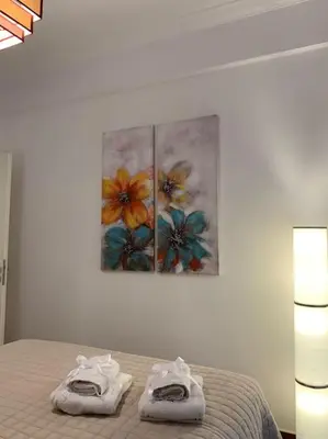 a bedroom with a bed with two paintings on the wall at Athens Flower Paradise near Acropoli in Athens