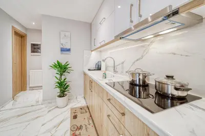 a white kitchen with two pots on the counter at Athens Riviera, seaview, beachfront, Lux Apartment on Starbucks building in Athens