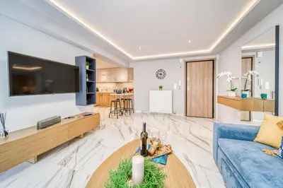 a living room with a blue couch and a table at Athens Riviera, seaview, beachfront, Lux Apartment on Starbucks building in Athens