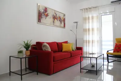 a living room with a red couch and two tables at 