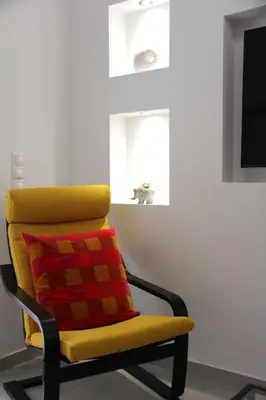 a yellow chair with a colorful pillow in a room at 
