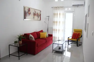 a living room with a red couch and two chairs at 