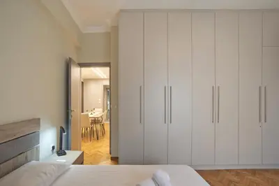 a bedroom with white cabinets and a dining room at Honey House Kipseli Stylish, Reno 2BR Apt City Ctr in Athens