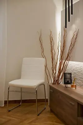 a white chair sitting next to a wooden dresser at Honey House Kipseli Stylish, Reno 2BR Apt City Ctr in Athens