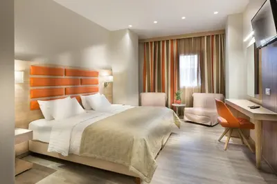 a hotel room with a bed and a desk at Jason Inn in Athens