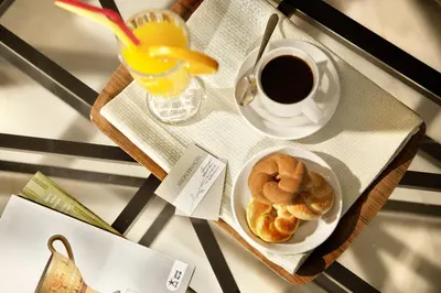 a table with a plate of pastries and a cup of coffee at Jason Inn in Athens