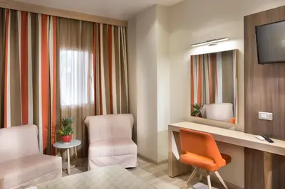 a room with a desk and two chairs and a television at Jason Inn in Athens